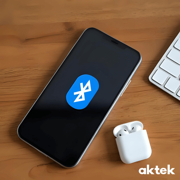 Смартфон с включённым Bluetooth рядом с наушниками на столе