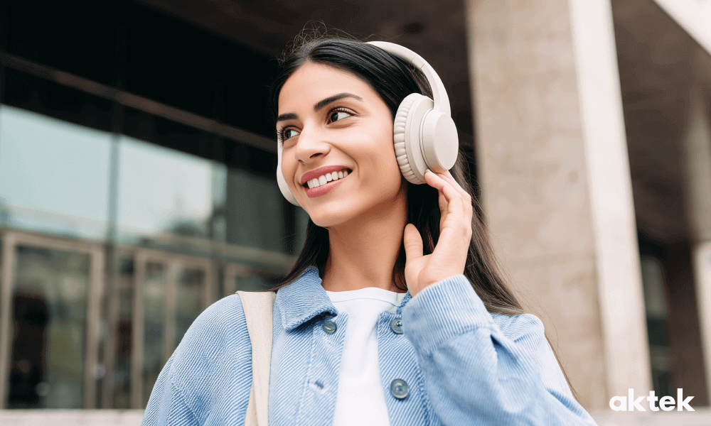 Девушка в полноразмерных наушниках типа over-ear на улице